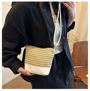 Détail d'un sac à bandoulière en paille tissée à la main avec base en cuir blanc et corde