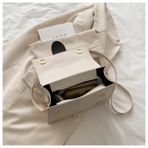 Détail de l'intérieur d'un sac à bandoulière beige montrant l'espace de rangement