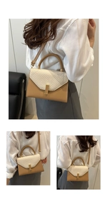 Detail of a minimalist crossbody bag featuring a woven beige flap and metal buckle