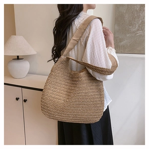 Detail of hand-woven straw shoulder bag with wide strap for summer beach vacations