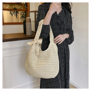 Close-up of woven shoulder bag with lace bow detail and elegant hollow-out texture