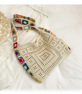 Detail view of Bohemian beige crochet tote bag with vibrant floral knit strap and pattern