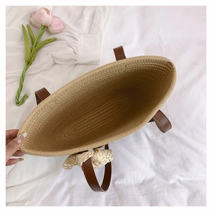 Vue de dessus d'un grand sac cabas en paille avec nœud en dentelle et intérieur spacieux