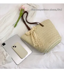 Detail of woven straw tote bag compared with tablet and phone to show large capacity
