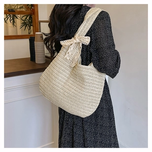 Close-up of a large beige straw handbag with a decorative lace bow for summer beach use