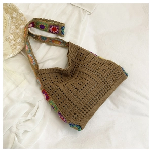 Close-up of bohemian knit bag with colorful crochet floral details and hollow mesh texture