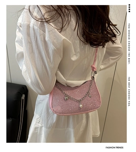 Pink sequin shoulder bag shown on model with silver chain and heart pearl charms