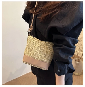 Détail du sac à bandoulière en paille tressée beige avec base en cuir et sangle