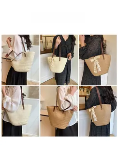 Detail showing natural straw weave, brown leather handles, and lace bow on a tote bag