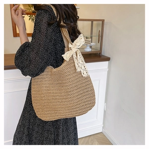 Detail of woven beach tote with white lace bow decoration and straw texture