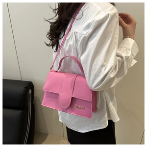 Vue détaillée du sac rose à rabat avec logo doré et finitions de couture faites main