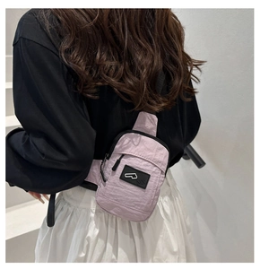 Dettaglio borsa da petto in tela viola con tracolla regolabile e logo rettangolare