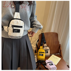 Dettaglio di borse a tracolla in nylon colorato con tasche a zip e cinturino regolabile