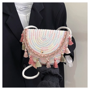 Dettaglio borsa a tracolla intrecciata boho con ricami colorati e nappe decorative