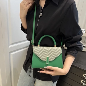 Minimalist green leather crossbody bag with herringbone woven flap and gold buckle