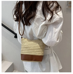 Détail d'un sac seau tissé main avec base marron et bandoulière sur un mannequin
