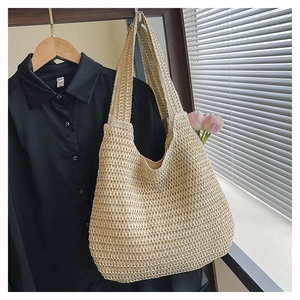 Close-up of beige woven tote bag with open-knit texture and elegant pink tulips