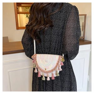 Dettaglio della borsa a tracolla intrecciata boho con motivi a onde colorate e nappe