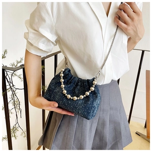 Deep blue denim bucket bag featuring a large silver bead handle and metal chain strap
