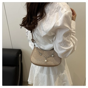 Detail view of stylish glitter shoulder bag with silver chain pearl and heart charms