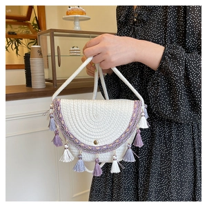 Dettaglio della borsa da spiaggia tessuta boho con nappe viola e ricami etnici