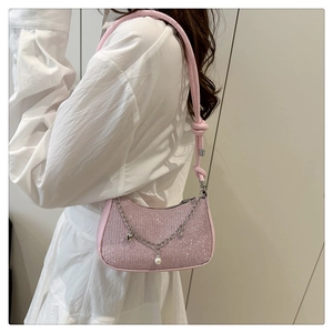 Detail of pink glitter shoulder bag with silver chain, white pearls and heart charms