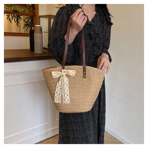 Detail of hand-woven straw tote with elegant lace bow and leather straps