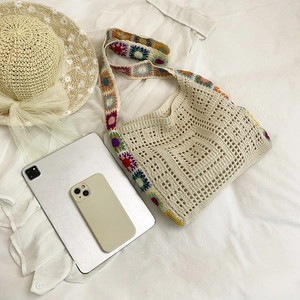 Bohemian crochet knit shoulder bag with colorful floral patterns on white background
