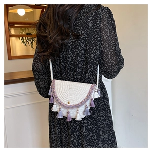 Borsa a tracolla intrecciata bianca bohémien con ricamo viola e frange su abito a pois