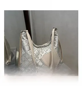 Macro detail of silver floral jacquard fabric and white leather strap on a tote bag