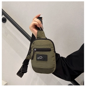 Dettaglio della borsa a tracolla in nylon verde militare con patch MX e rete nera