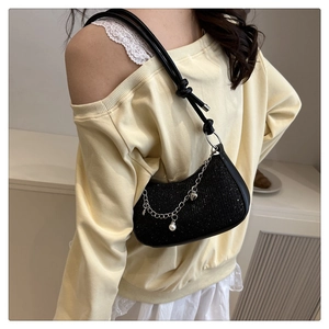 Detail of black sequined underarm bag with silver chain, pearls and heart pendant