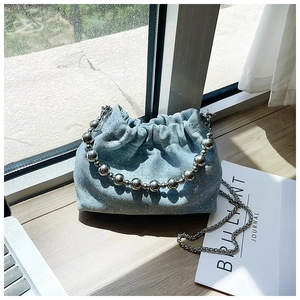 Detail of light blue denim bucket bag with silver sequins and metallic ball handle