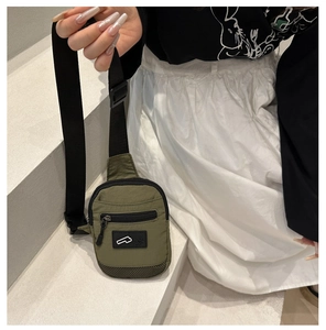 Dettaglio della borsa a tracolla in nylon verde militare con spallina regolabile