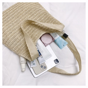 Detail of hand-woven beige straw tote showing large capacity for tablet and cosmetics