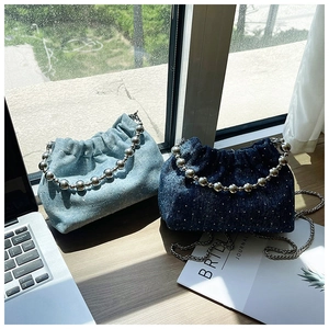 Detail of denim bucket bags with rhinestones, silver bead handles and metal chains