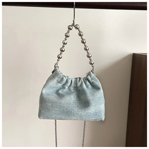 Detail of light blue denim bucket bag with sparkling rhinestones and silver bead handle