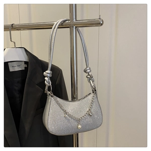 Detail of silver sequin crescent bag with metallic handle and decorative pearl star chain