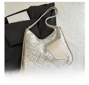 Detail view of silver jacquard pattern shoulder bag with beige trapezoid pocket