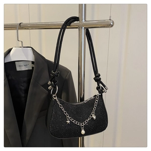 Detail of black crescent shoulder bag with glitter finish and star pearl chain charm