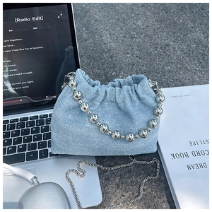 Detail of light blue denim bucket bag with sparkling rhinestones and silver bead handle