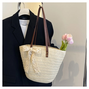 Detail of woven straw tote bag with white lace bow and elegant tulip decoration