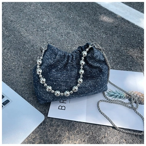 Detail of blue denim bucket bag with silver glitter dots and large metallic bead handle