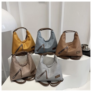 Detalle de bolsos tote en varios colores con patrón de espiga y correas dobles