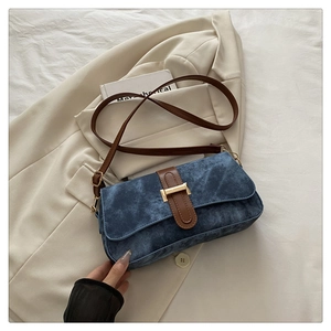 Détail du sac baguette bleu avec garniture en cuir marron et fermoir en métal doré