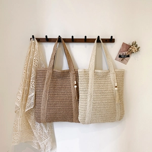 Handwoven straw tote bags in brown and cream with rustic wooden bead tassel details