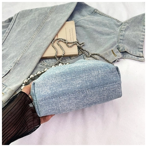 Detailed macro view of denim bucket bag fabric with sparkling silver rhinestone studs