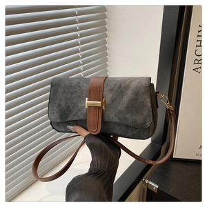 Détail du sac baguette en tissu gris avec bandoulière en cuir brun et fermoir doré H