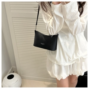 Minimalist black leather crescent bucket bag showing shoulder carry fit and proportions