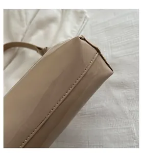 Dettaglio della borsa in vernice beige con finitura lucida e cuciture ben rifinite